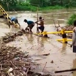 Kondisi Jembatan Kacangan, Kecamatan Benjeng, Gresik, yang penuh sampah saat debit air di Kali Lamong naik. Foto: Ist