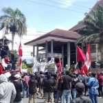Aksi ratusan massa gabungan buruh dan mahasiswa saat demo menolak RUU Omnibus Law di depan kantor DPRD Jember.