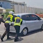 Petugas Satlantas Polres Gresik mendorong mobil pemudik yang mogok. Foto: Ist