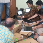 Para teknisi dari Politeknik Negeri Madiun saal melakukan pengecekan laptop yang baru datang. Foto : Hendro Suhartono/BANGSAONLINE.com