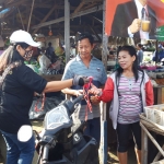 Salah satu relawan dari Laskar Sri Aji Joyoboyo Kediri saat membagikan masker kepada pedagang di Pasar Deso Sumberjo Kecamatan Ngasem, Kabupaten Kediri. foto: MUJI HARJITA/ BANGSAONLINE
