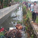 Petugas menunjukkan lokasi penemuan mayat tukang becak di dalam parit.