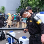 Para petugas penyemprot disinfektan sedang bersiap di Taman Surya.