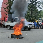 Suasana saat demo dari puluhan aktivis yang diwarnai dengan bakar ban di depan Kantor Cabang Dinas Pendidikan Jatim Wilayah Kediri. Foto: MUJI HARJITA/ BANGSAONLINE