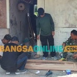 Anggota Satgas TMMD ke-122 saat menyelesaikan renovasi rumah tidak layak huni. Foto: MUJI HARJITA/BANGSAONLINE