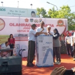 Kapolres Pacitan saat menyerahkan doorprize jalan sehat dalam rangka deklarasi damai tolak kerusuhan di Alun-alun Pacitan.