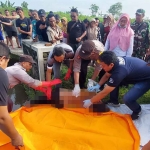 Petugas saat mengevakuasi mayat perempuan di Desa Pacarpeluk, Kecamatan Megaluh, Jombang.