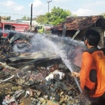 Petugas sedang memadamkan sisa api.