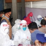 Para petugas medis sedang melakukan rapid test massal di Pasar Sidoharjo.
