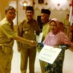 Wabup, Moh Qosim didampingi Kepala DPU, Bambang Isdianto menyerahkan bantuan bedah rumah gakin. (syuhud/BANGSA)