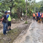 Tim URC Bima DPUTR Gresik membersihkan material longsor yang menimbun akses jalan di Kecamatan Sangkapura, Pulau Bawean. Foto: Ist.