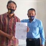 Pekerja bantuan hukum anggota Pos Batu LBH Malang Endro Ardi Nugroho, S.Sos. dan Rohmat Basuki, S.H., menunjukkan surat keterangan kutipan Letter C dari Desa Torongrejo.