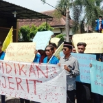 Mahasiswa PMII demo di depan pintu kantor Dinas Pendidikan Kabupaten Bangkalan, Kamis (26/12).