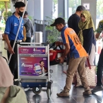 Petugas saat membantu penumpang di stasiun.