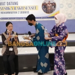 Guru tamu dari Jepang, Takatsuka Raku, mencicipi jajanan tradisional saat penyambutan oleh Smamda Sidoarjo. Foto: MUSTAIN/BANGSAONLINE