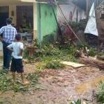 Warga melihat kerusakan akibat puting beliung yang melintas di desa mereka. 