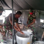 Anggota TNI dari Kodim Sidoarjo mendapat tugas memasak nasi.