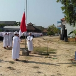 Proses menaikkan bendera merah dalam upacara Hari Santri Nasional di Ponpes Matholiul Anwar, Lamongan.
