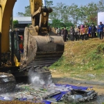 Pemusnahan miras di sekitar TPA Banjarsari menggunakan alat berat bego. 