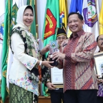 Wali Kota Batu Dewanti Rumpoko saat menerima penghargaan dari Menteri Dalam Negeri Tito Karnavian.
