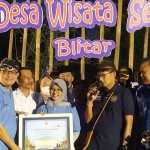 Menteri Pariwisata dan Ekonomi Kreatif Sandiaga Uno (pegang mik) memberikan piagam penghargaan kepada Desa Semen sebagai satu dari 50 desa yang masuk Anugerah Desa Wisata Indonesia (ADWI) 2022.