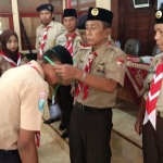 Ketua Harian Kwarcab Sumenep, Drs. H. M. Siraj Aidy, M.Si. saat memakaikan ID card kepada peserta pelatihan.