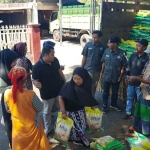 Mahasiswa BEM Pasuruan Raya bersama jajaran Polres Pasuruan saat mendistribusikan beras murah ke warga desa.