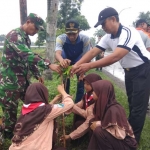 Anggota Kodim 0812 beserta para siswa saat menanam bibit pohon.