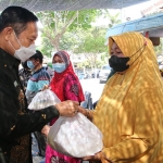 Bupati Yuhronur Efendi saat menyerahkan bansos kepada pedagang di Kompleks Makam Sunan Drajat. (foto: ist)