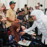 Gubernur Khofifah saat menyapa salah satu warga ketika menyalurkan bantuan sosial di Pendopo Kabupaten Madiun.