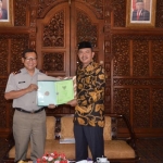 Bupati Mojokerto Pungkasiadi, menerima sertifikat tanah secara simbolis dari Kepala Badan Pertanahan Nasional (BPN) Kabupaten Mojokerto Hendy Pranabowo. 