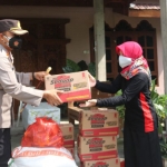 Kapolres Ngawi menyerahkan bantuan sembako kepada warga Desa Puhti yang menjalani isolasi mandiri secara simbolis.