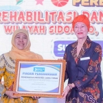 Gubernur Khofifah saat menerima piagam penghargaan.