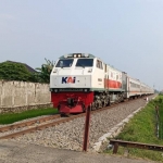 Sebuah rangkaian kereta api sedang melintas di Kediri. (foto: MUJI HARJITA/ BANGSAONLINE)