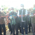 Kasi Pemberdayaan Lembaga Ekonomi Desa DPMD Jawa Timur, Lianto, menggunting pita tanda diresmikannya wisata Coban Goa Jalmo, di Desa Cendono, Kecamatan Purwosari, Kabupaten Pasuruan.