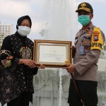 Wali Kota Risma memberikan piagam penghargaan kepada Kapolrestabes Surabaya, Brigjen Pol Sandi Nugroho. (foto: ist).
