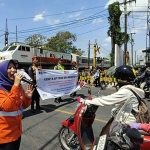 Petugas KAI Daop 7 Madiun saat melakukan sosialisasi keselamatan perjalanan KA di JPL Nomor 286, Jalan Hasanudin, Kota Kediri. Foto: MUJI HARJITA/ BANGSAONLINE 