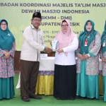 Ketua PD Dewan Masjid Indonesia (DMI) Gresik, Zainal Abidin menyerahkan cindera mata kepada Wabup Aminatun Habibah. Foto: SYUHUD/BANGSAONLINE.com