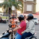 Petugas gabungan saat membagikan replika Bendera Merah Putih kepada pengguna jalan. foto: ist.