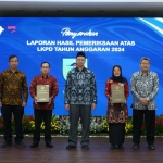 Wakil Bupati Dewi Mariya Ulfa saat menerima LKPD dari Plh. Kepala BPK RI Perwakilan Jawa Timur Ayub Amali (tengah). (Ist). 