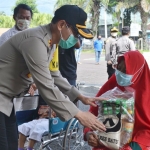 Kapolres Batu AKBP Harviadhi Agung Prathama menyerahkan bantuan beras kepada salah seorang difabel.