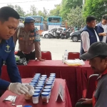 Petugas saat mengambil sample tes urine para sopir bus di Terminal Purabaya, Senin (23/12/2024). Foto: Ist.