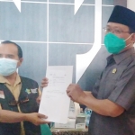 Ketua DPRD Kabupaten Pasuruan M Sudiono Fauzan (kanan) saat menerima kartu vaksin dari petugas Dinkes setempat.