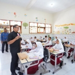 Pj Aries saat menemui siswa SDN Gunungsari 1 Kota Batu dalam uji coba program makan siang bergizi gratis