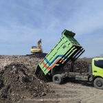 Dump truk dari DLH Kota Mojokerto ketika menimbun TPA Randegan dengan tanah urug untuk mengurai sisa kebakaran.