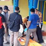 Petugas saat mengevakuasi pemuda yang tewas mengenaskan di teras musala Dusun Ngares, Desa Ngares Rejo, Kecamatan Sukodono, Sidoarjo.