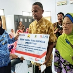 Wali Kota Mojokerto Ika Puspitasari menyerahkan tabungan kepada penerima bantuan BSPS.