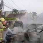 Petugas pemadam kebakaran saat memadamkan api pada Mobil Kia Picanto yang terbakar, Selasa (15/11/2022)
