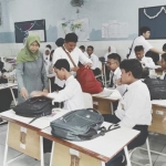 Petugas OPD gabungan Kota Surabaya saat memeriksa HP milik para siswa.