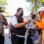 Petugas gabungan saat membagikan makanan pada warga di Jombang.